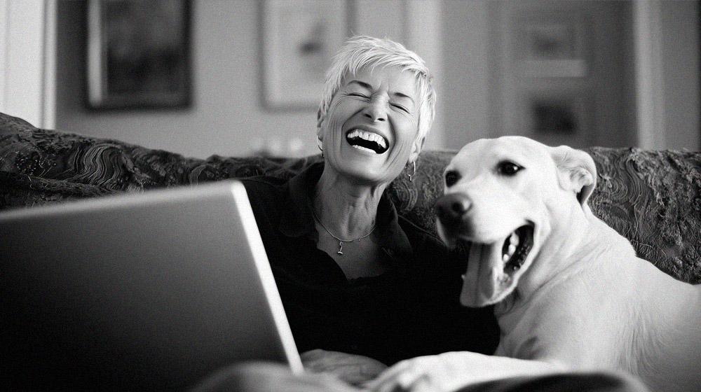 Woman and her dog laughing and watching youtube